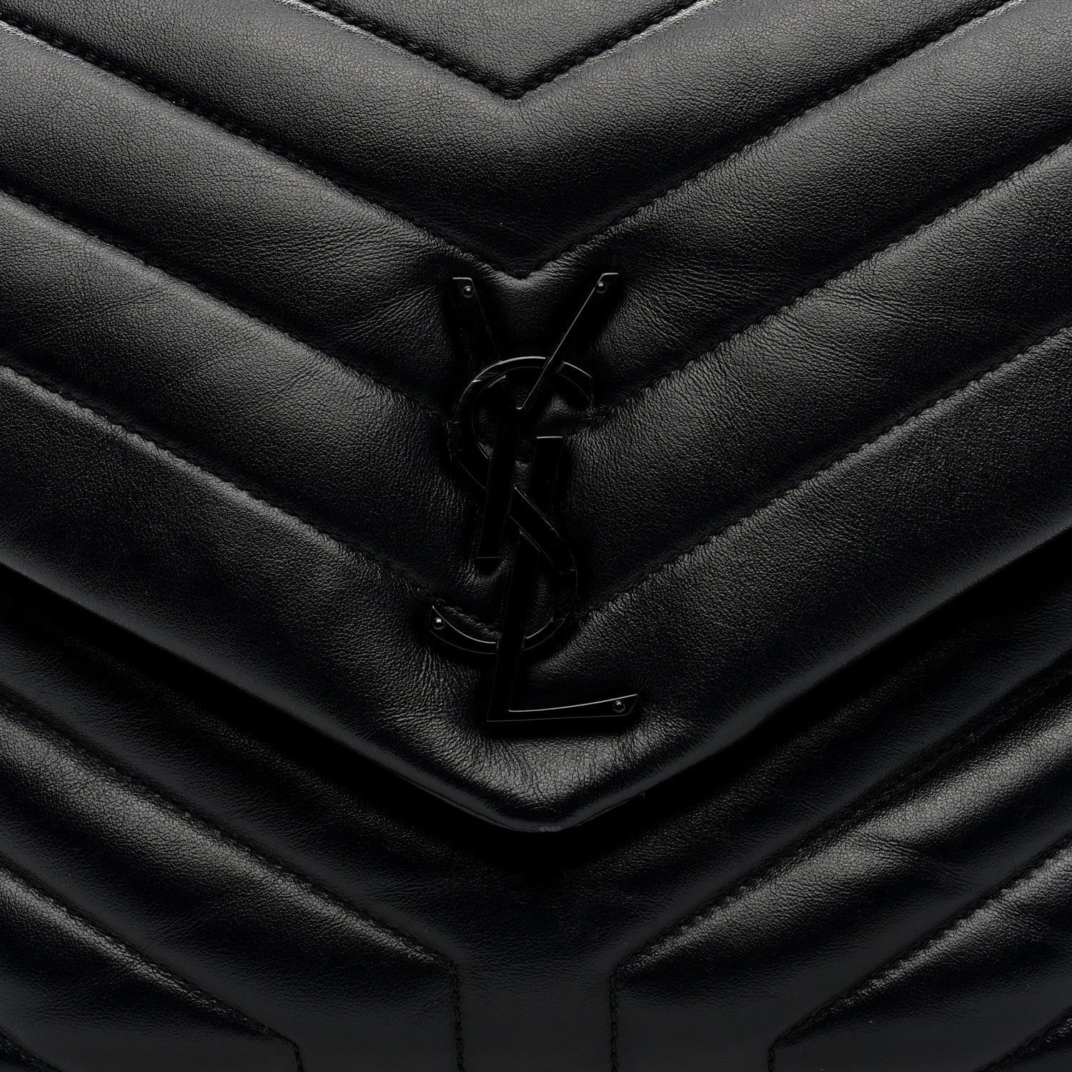 Black quilted satchel front flap with YSL logo clasp detail