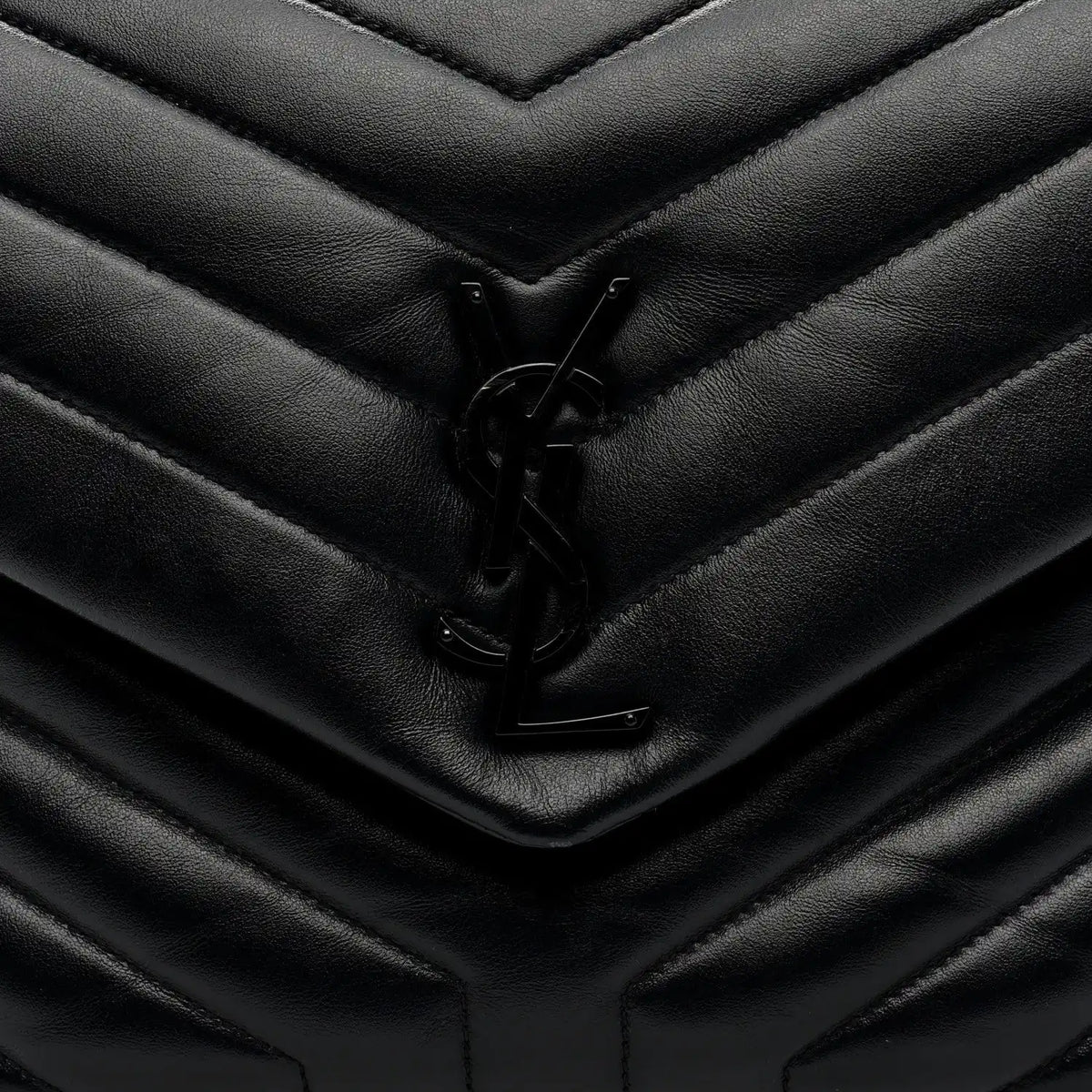 Black quilted satchel front flap with YSL logo clasp detail