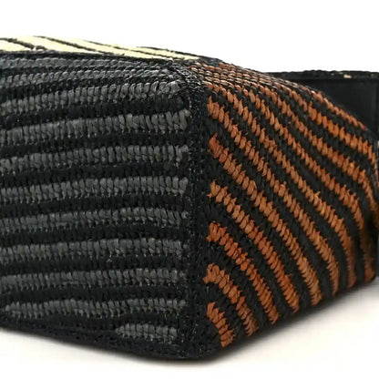 Small raffia puzzle bag weave detail with black and orange striped pattern