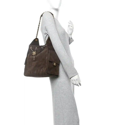 Dark brown suede quilted medium 25 handbag with chain strap, side view on mannequin