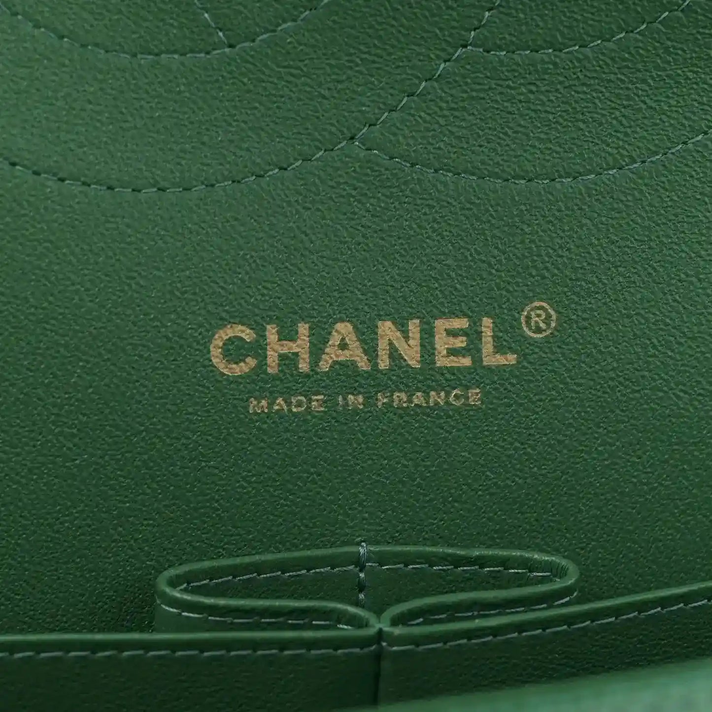Green Chanel leather bag interior panel with CHANEL logo and metal snap ring.