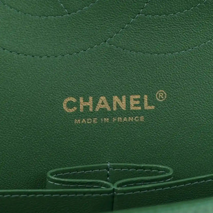 Green Chanel leather bag interior panel with CHANEL logo and metal snap ring.