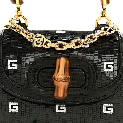 Gucci mini top handle bag front, black embossed lizard texture, bamboo tab and gold chain