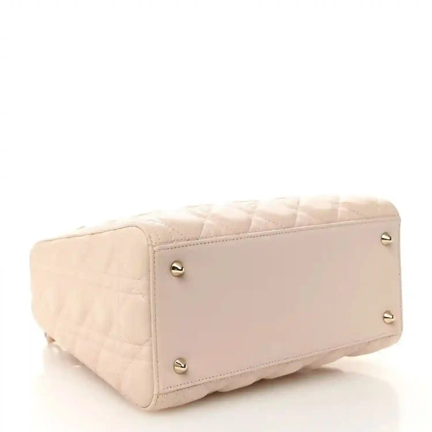 Powder pink quilted handbag end panel with gold-tone studs and top zip edge.