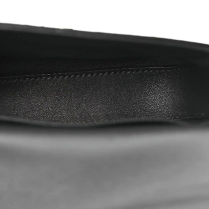 Close-up of black leather strap edge on grey snakeskin shoulder bag