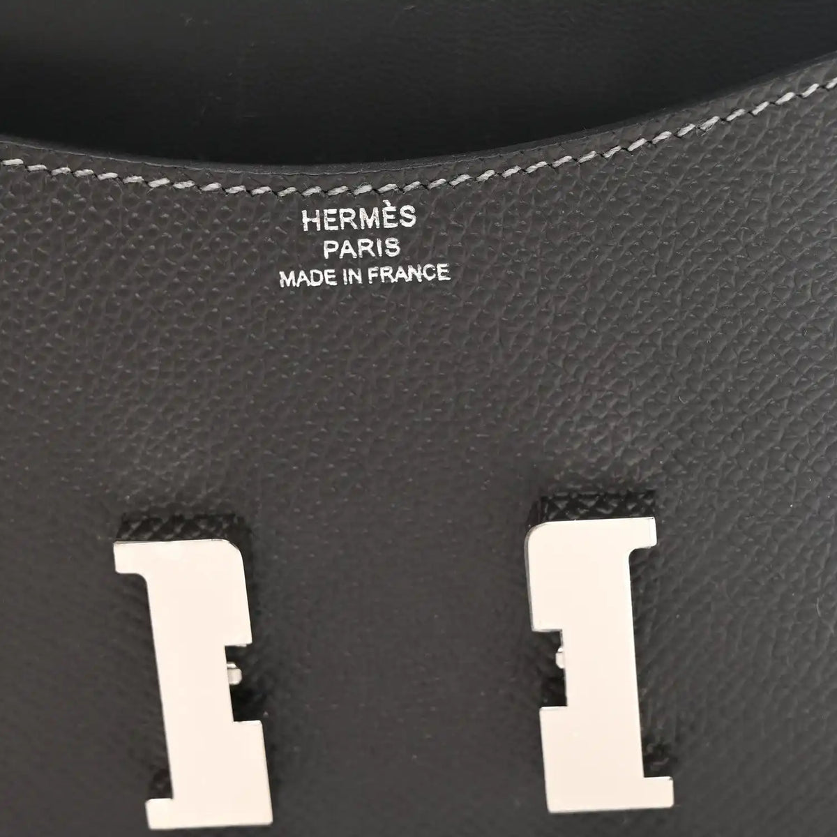 Constance slim wallet interior, dark textured leather with embossed brand text