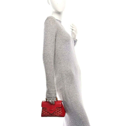 Red mini handbag with flap and small top handle, shown on a strap.