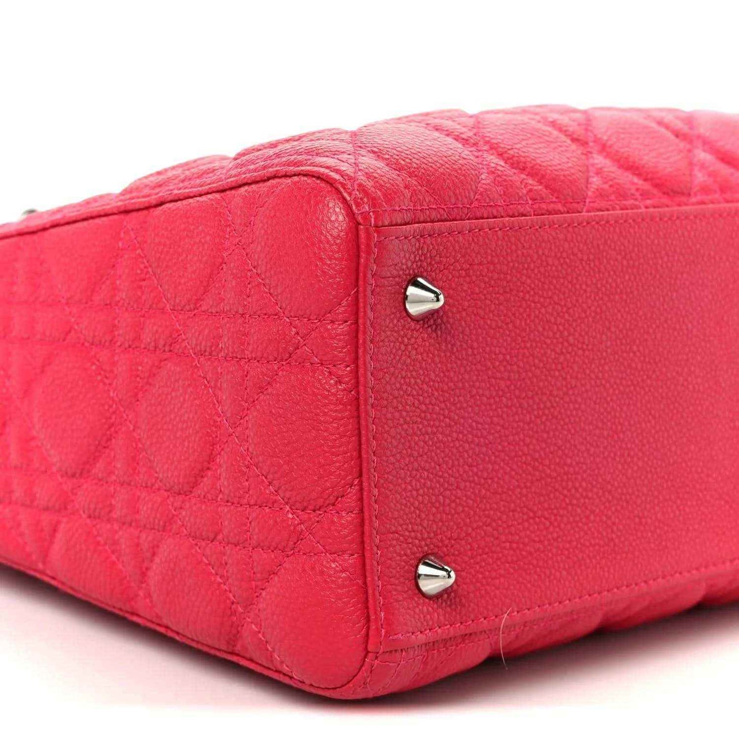 Pink quilted handbag corner with two silver feet studs