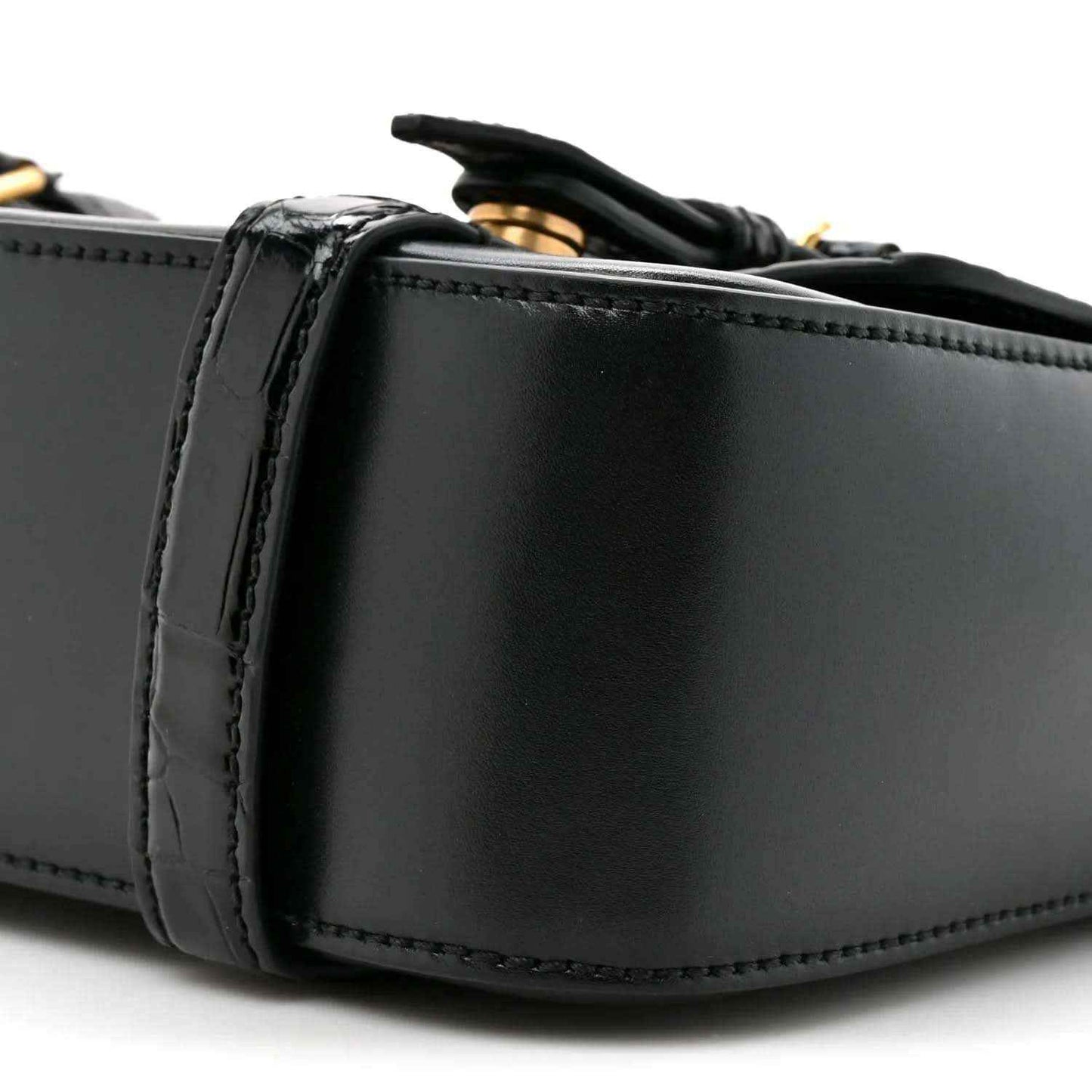 Black leather messenger bag close-up of side panel and stitched edging