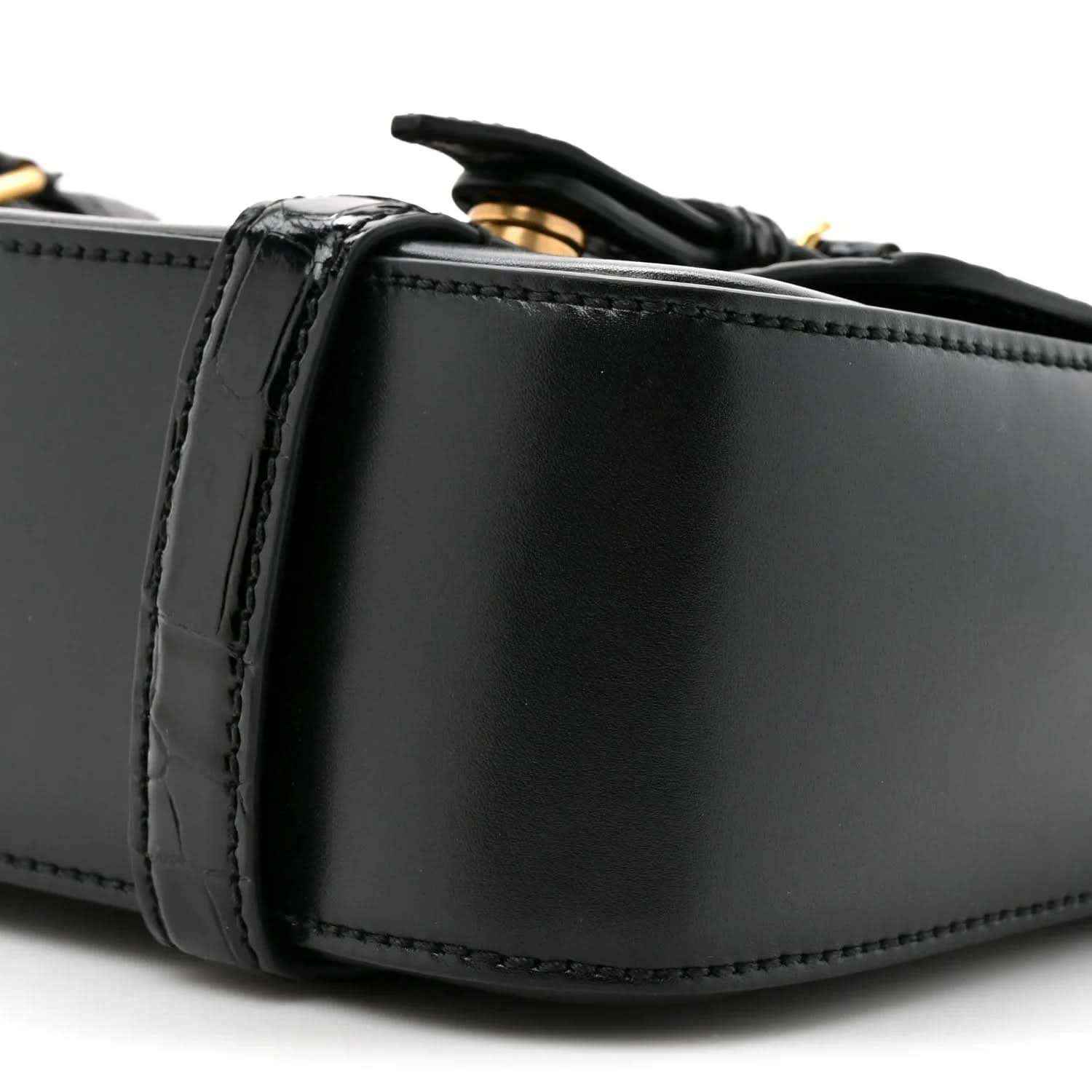 Black leather messenger bag close-up of side panel and stitched edging