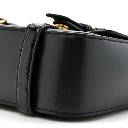 Black leather messenger bag close-up of side panel and stitched edging