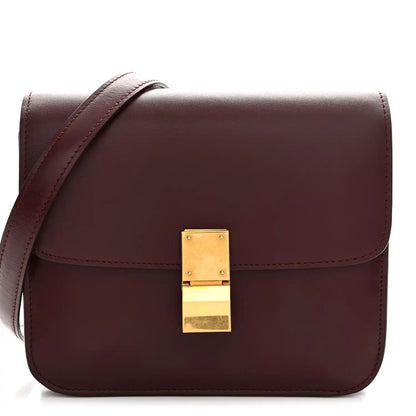 Burgundy leather box flap bag with gold-tone front clasp and top handle strap.
