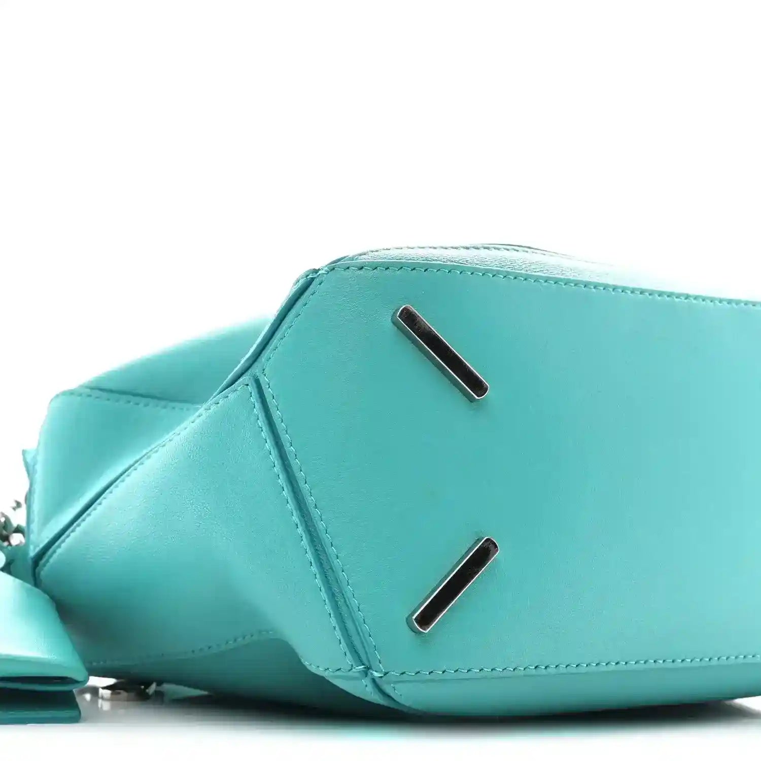 Teal-blue small Puzzle bag profile with two metal bar accents on the flap area.