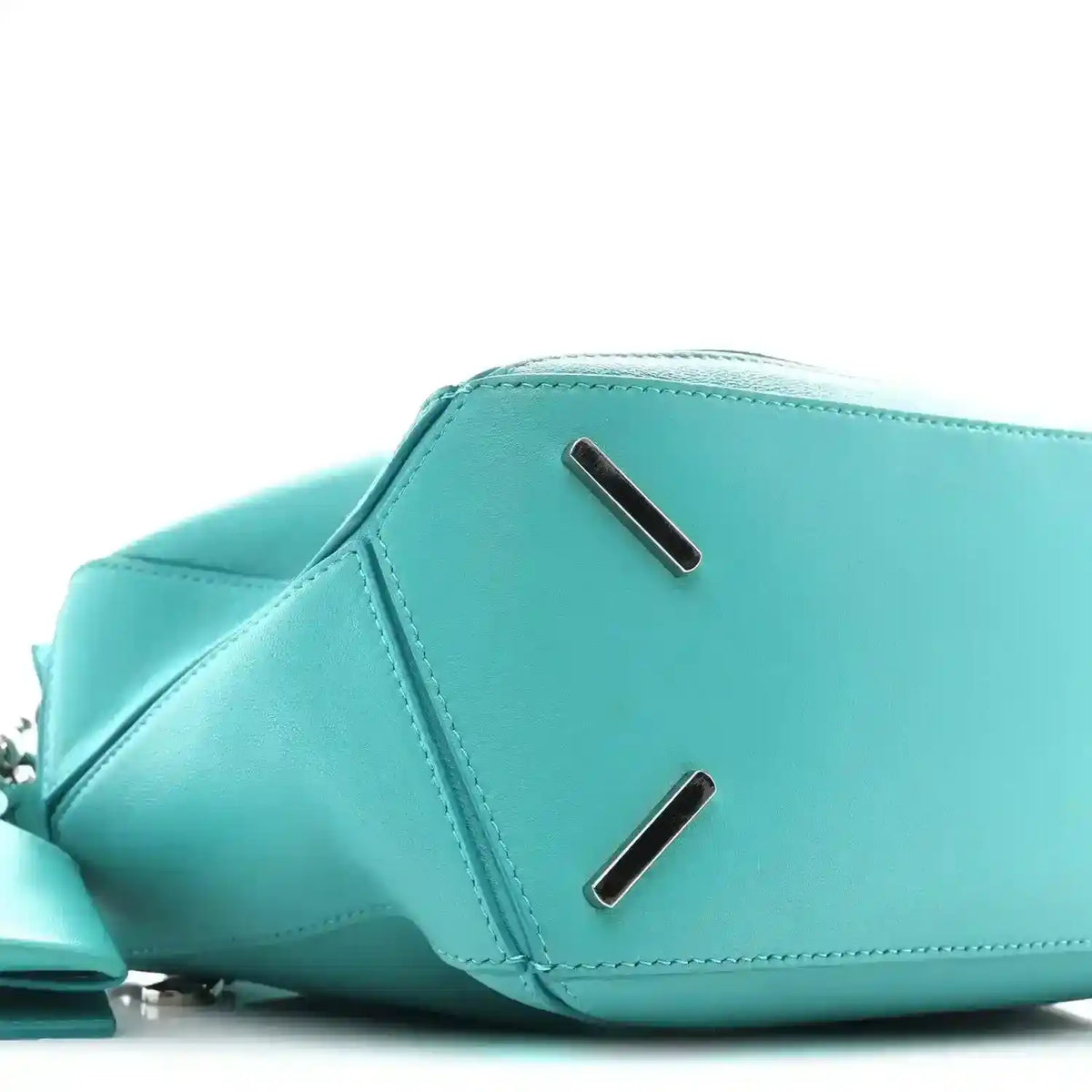 Teal-blue small Puzzle bag profile with two metal bar accents on the flap area.