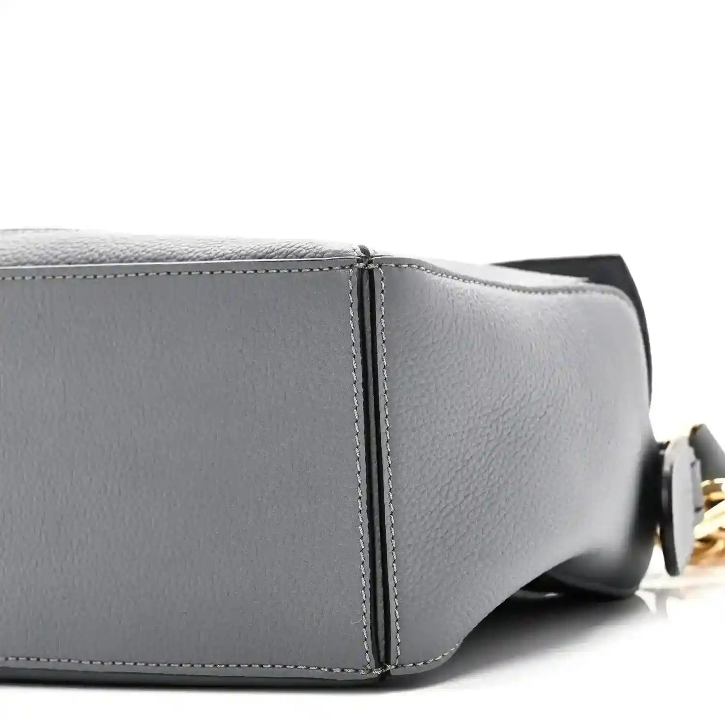 Small puzzle bag side seam close-up in dark gray leather with zipper-end hardware