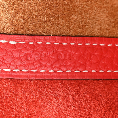 Red leather strap with white contrast stitching on brown lining, close-up