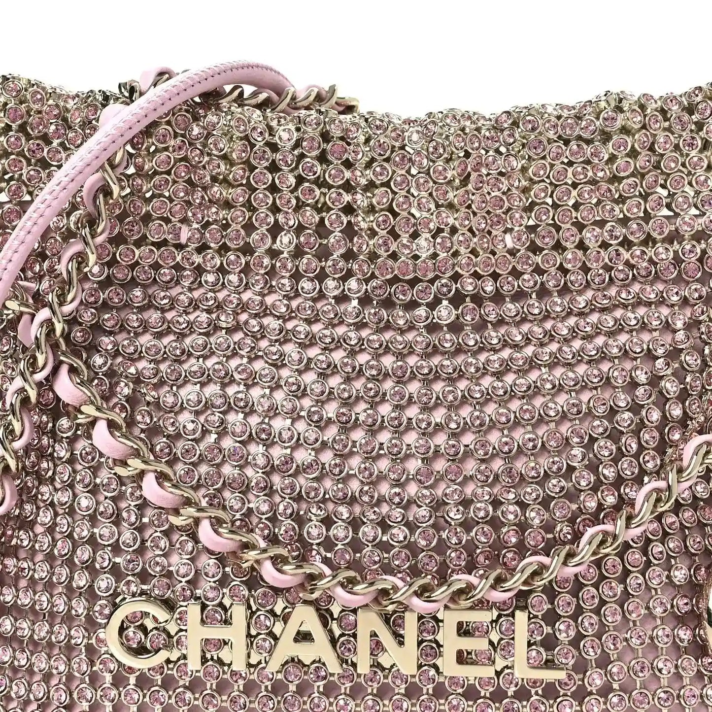 Chanel Mini 22 handbag close-up of pink crystal mesh, chain strap, and CHANEL lettering.