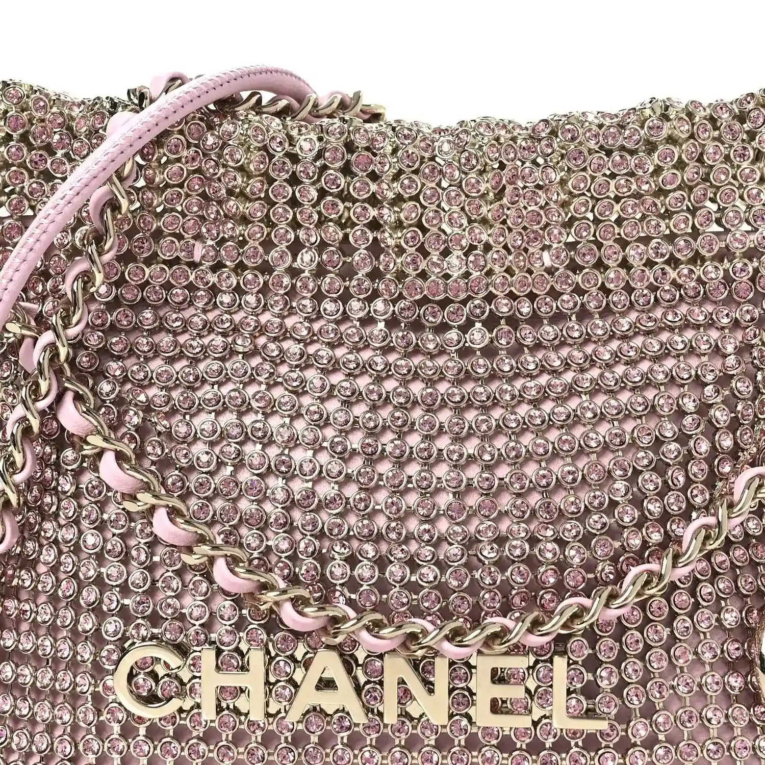 Chanel Mini 22 handbag close-up of pink crystal mesh, chain strap, and CHANEL lettering.