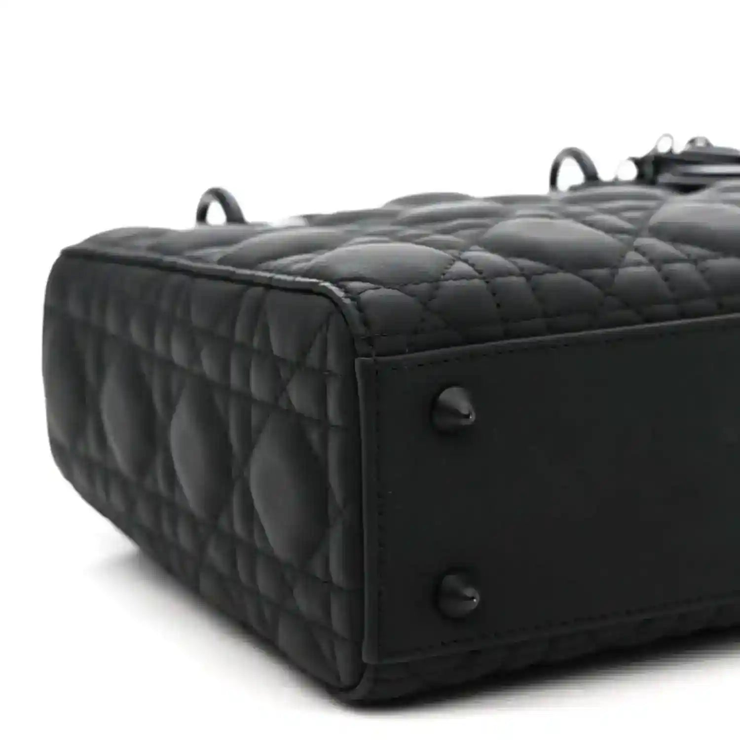 Black quilted handbag side with top handle rings and stitched edge trim