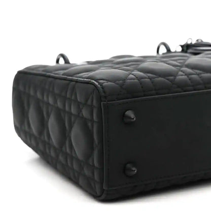 Black quilted handbag side with top handle rings and stitched edge trim