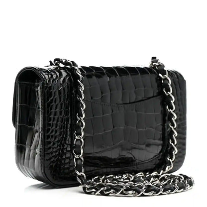 Black shiny alligator mini rectangular flap bag with silver-tone chain strap.