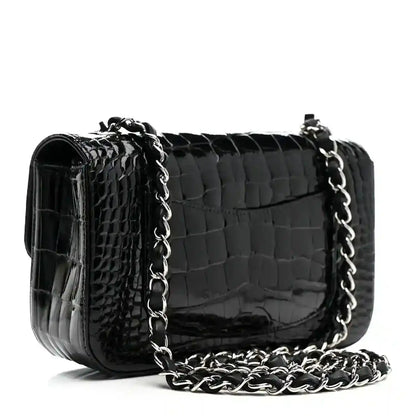 Black shiny alligator mini rectangular flap bag with silver-tone chain strap.