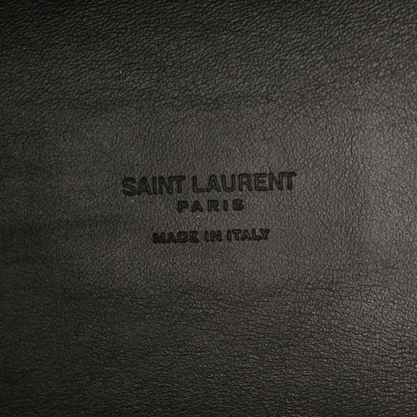 Saint Laurent Paris made in Italy embossing on black leather surface