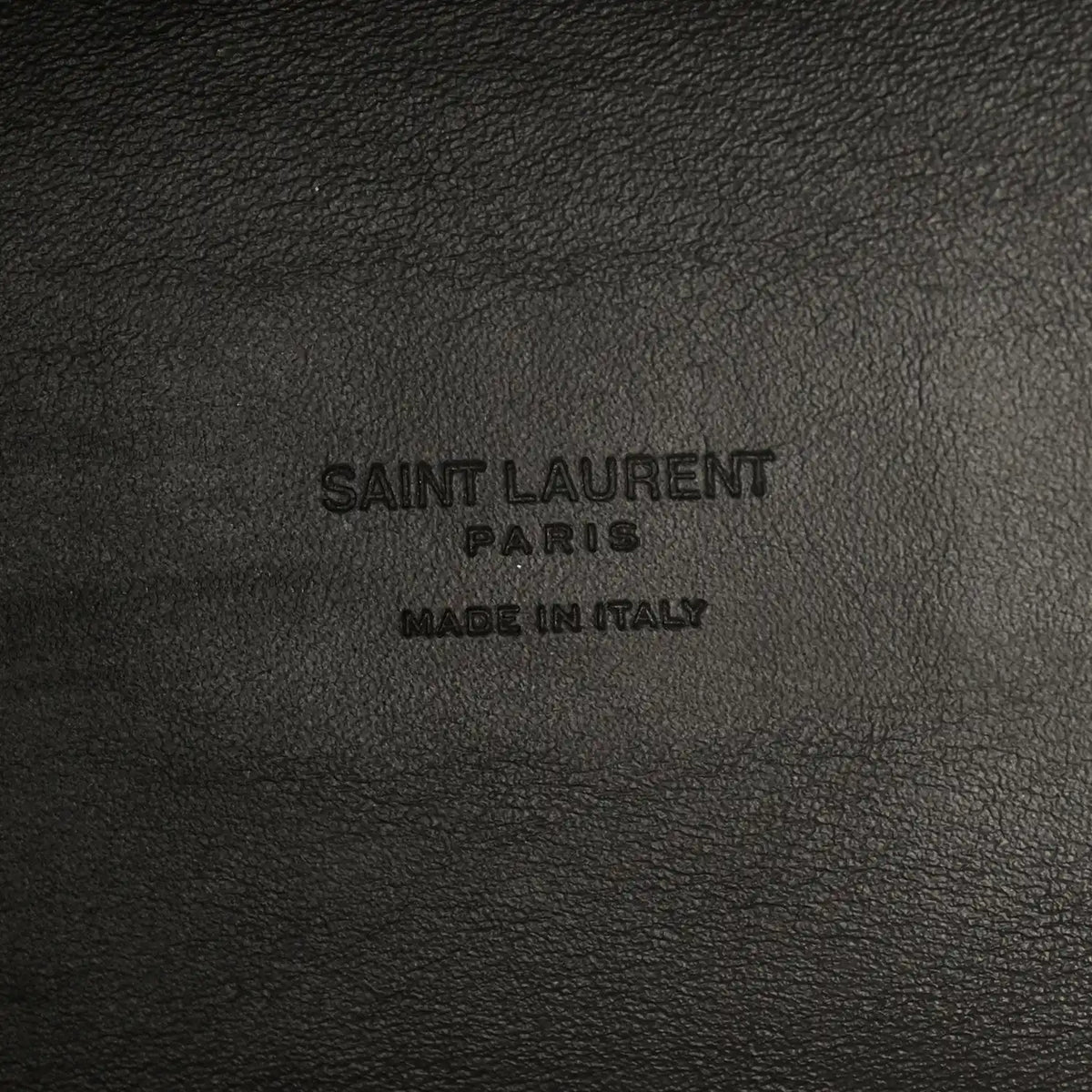 Saint Laurent Paris made in Italy embossing on black leather surface