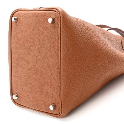 Cognac brown leather tote bag with squared sides, studs, and short top handles
