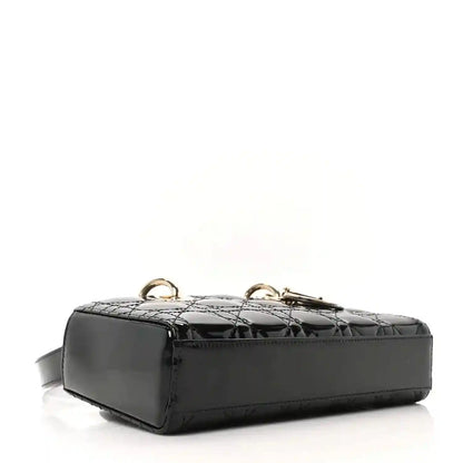 Black patent leather quilted bag base with gold-tone hardware and strap tab