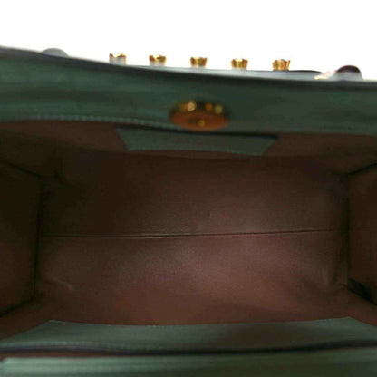 Green tote bag interior lining with stitched edges and logo hardware plaque