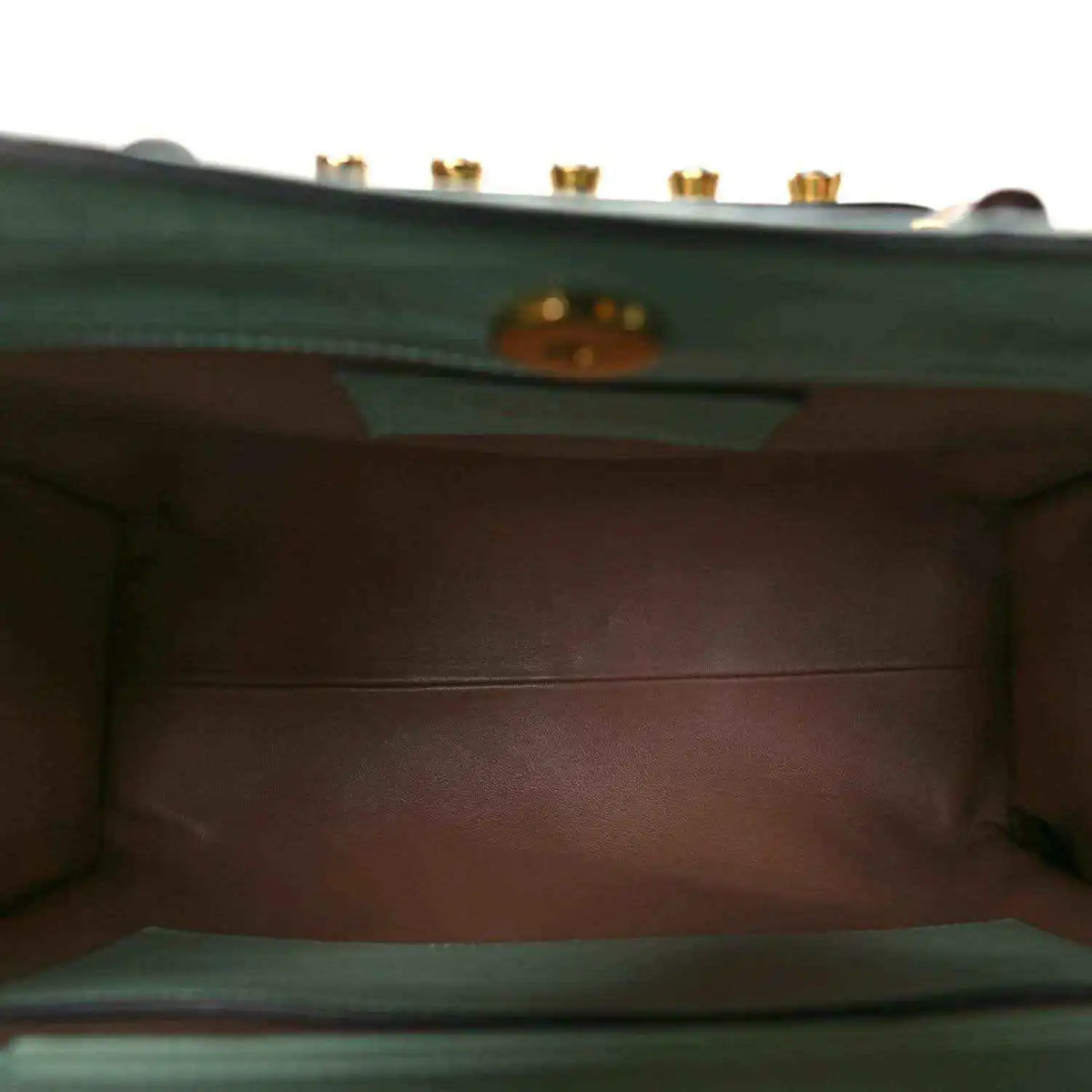 Green tote bag interior lining with stitched edges and logo hardware plaque