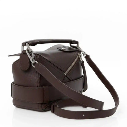Small leather biker bag with front flap, top handle, and crossbody strap in dark brown
