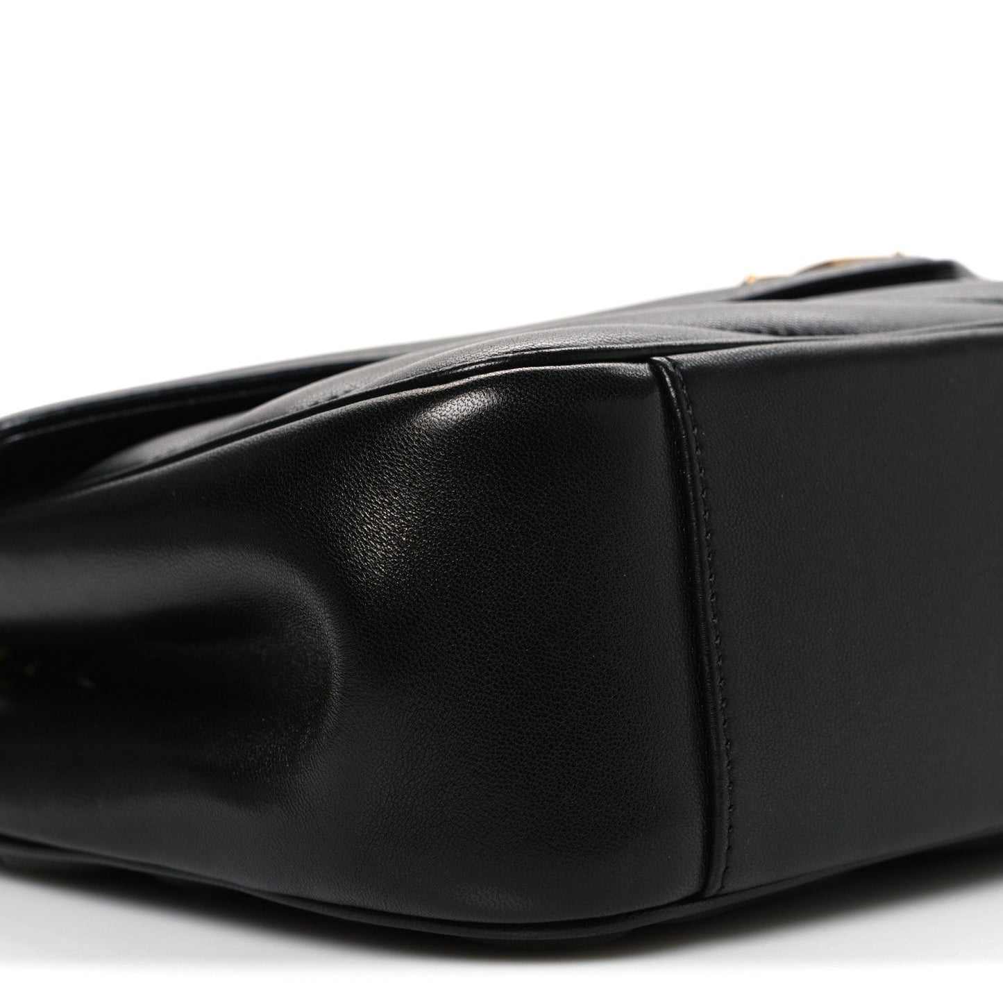 Black quilted leather shoulder bag with curved flap edge and visible seams