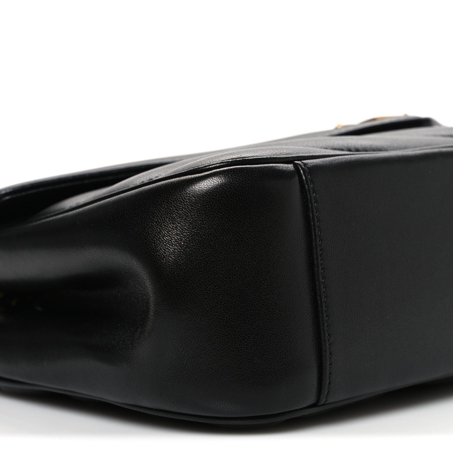 Black quilted leather shoulder bag with curved flap edge and visible seams