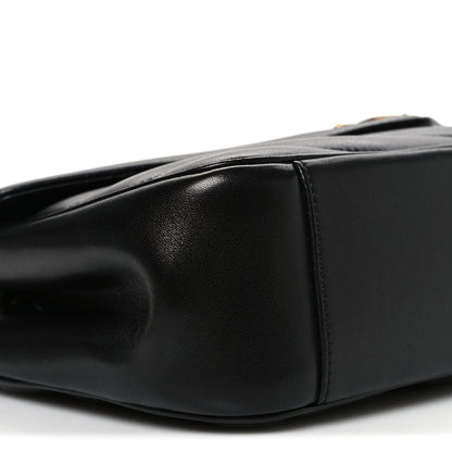 Black quilted leather shoulder bag with curved flap edge and visible seams