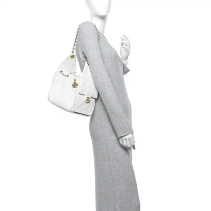 White quilted caviar leather handbag with chain strap, shown from the side