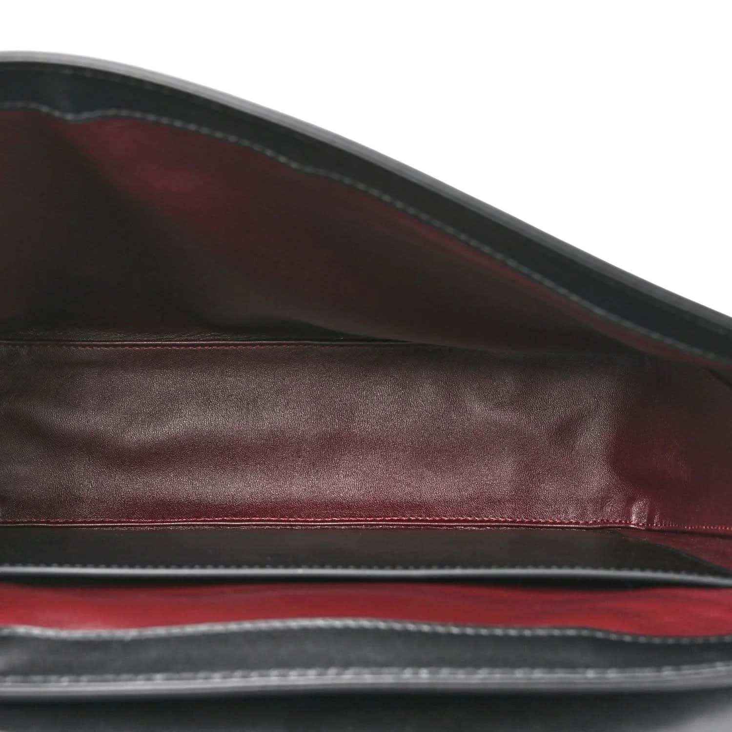 Black leather lining view with maroon-toned edge trim inside the bag