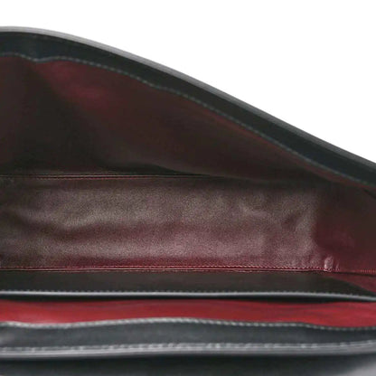 Black leather lining view with maroon-toned edge trim inside the bag