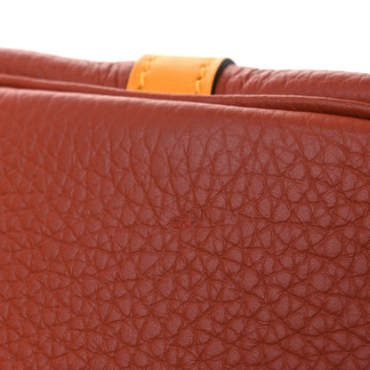 Red leather tote panel with copper-orange trim along the top edge