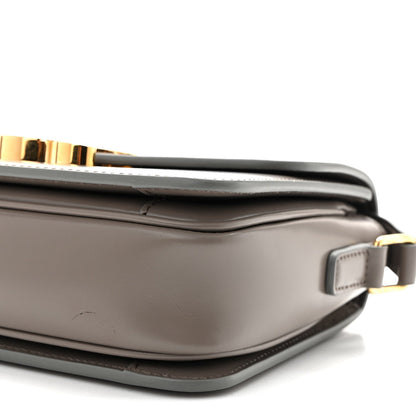 Celine shiny calfskin bag corner detail with gold-tone bar and strap hardware, light gray