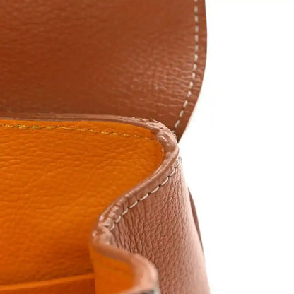 Mini shoulder bag edge with tan leather stitching and curved seam detail