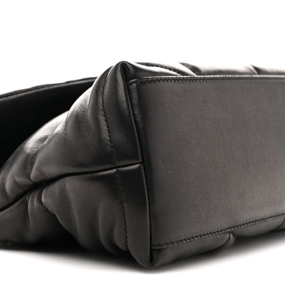 Black quilted puffer satchel corner with structured leather panel
