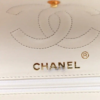 White leather flap with Chanel logo and stitched decorative border