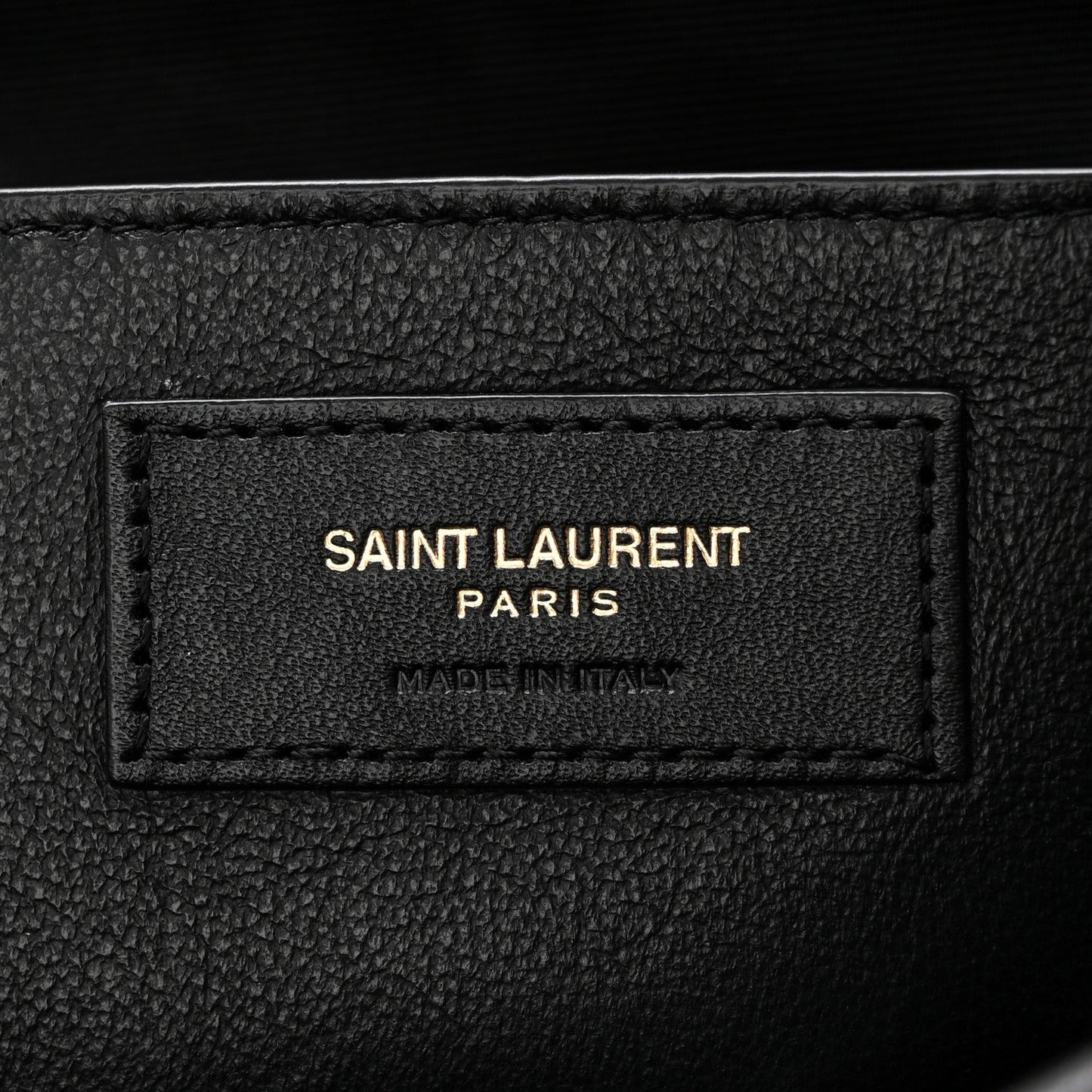 Black leather brand patch reading SAINT LAURENT PARIS, made in Italy