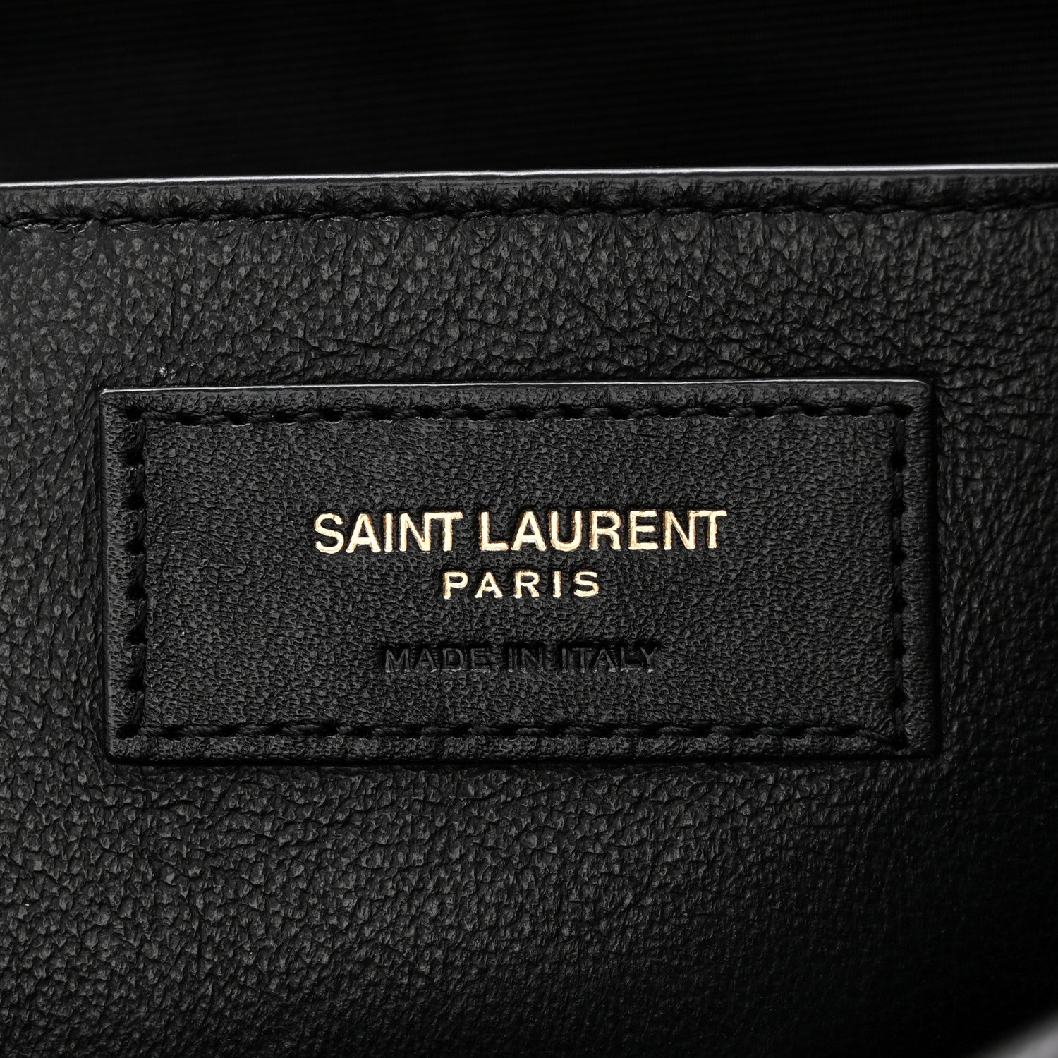 Black leather brand patch reading SAINT LAURENT PARIS, made in Italy