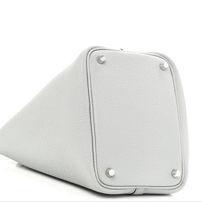 Light blue pebbled leather bucket bag side with metal corner studs and base seam
