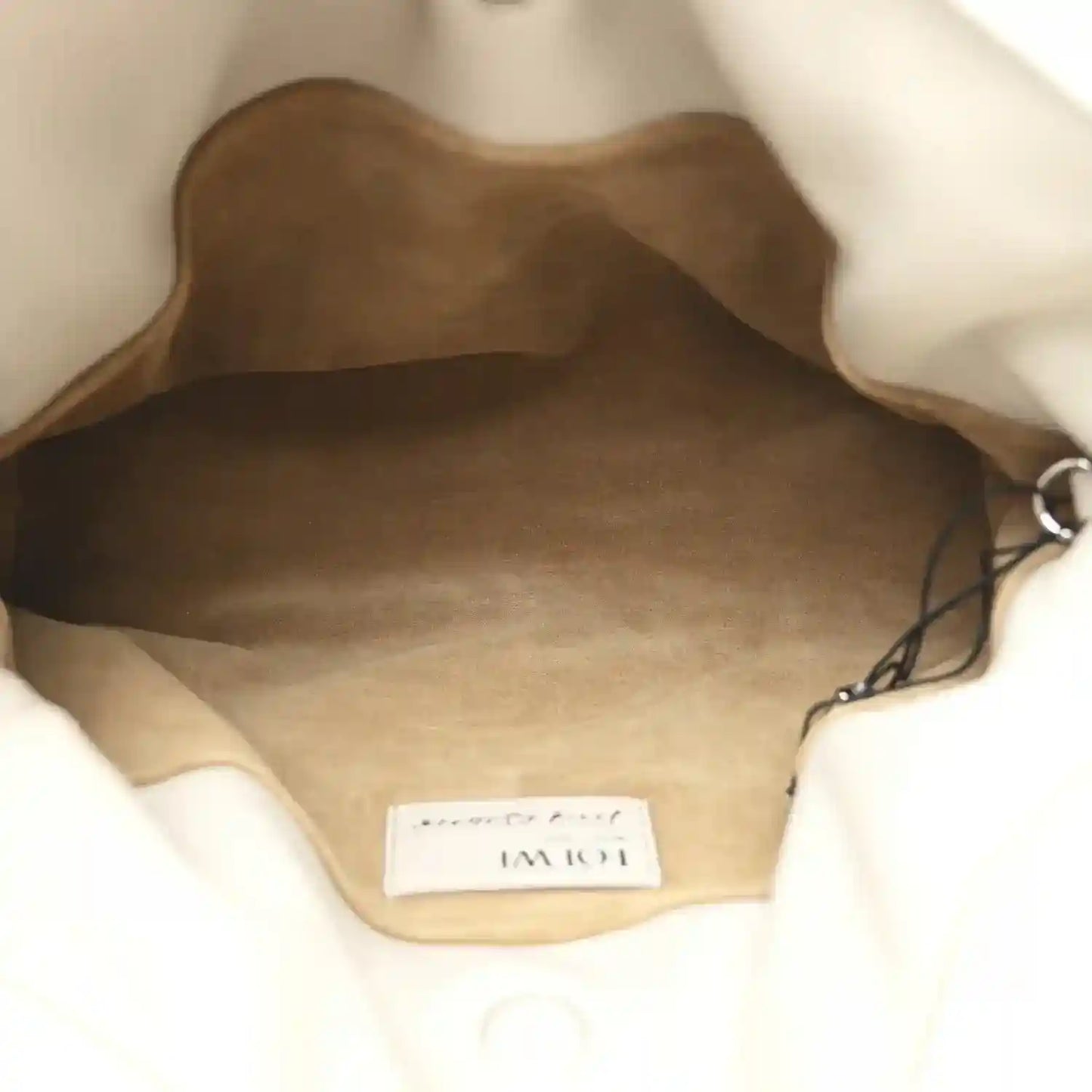 Leather clutch interior showing brand tag and stitched seam near opening