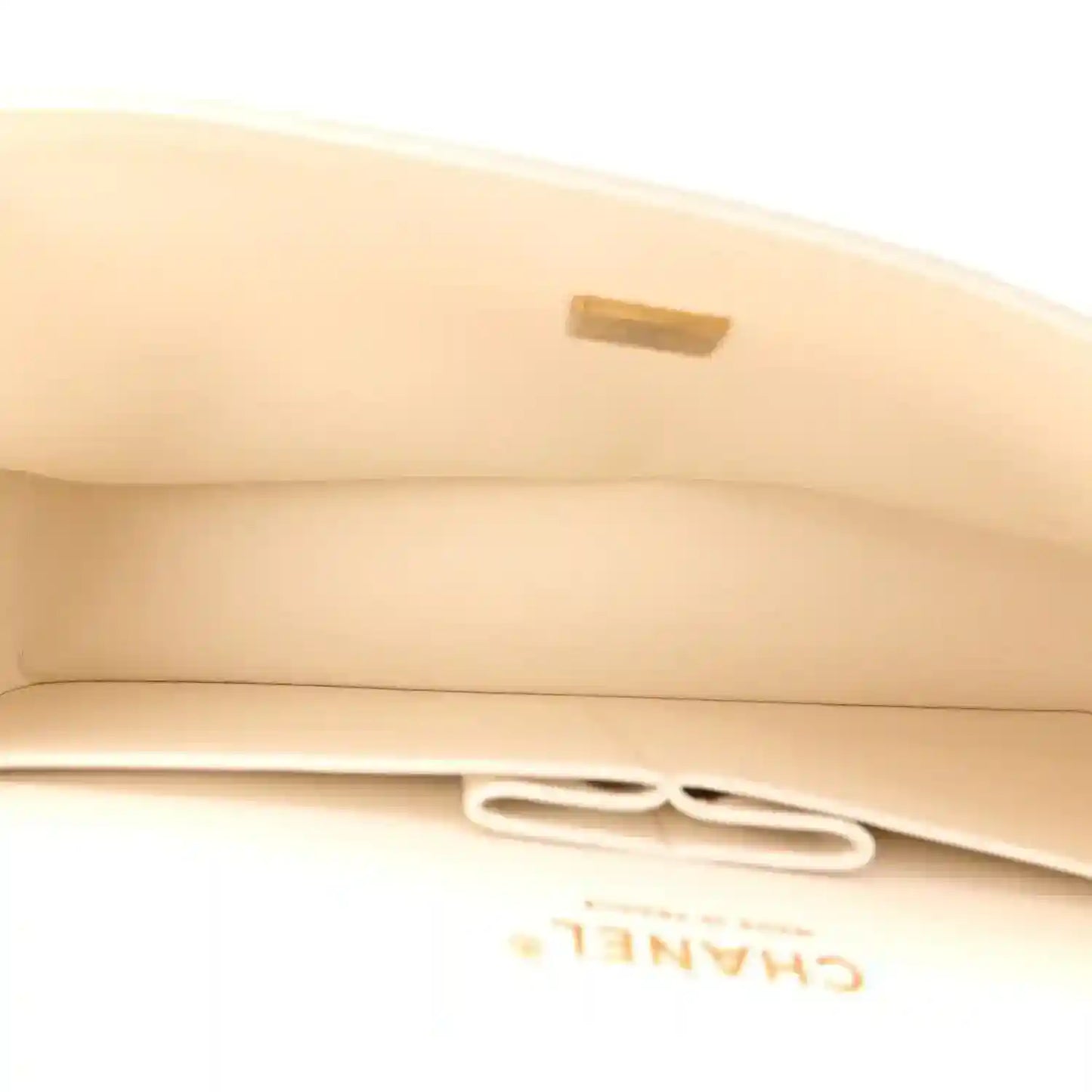 White quilted bag flap with gold-tone clasp detail