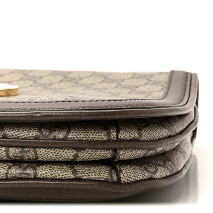 Bag corner showing beige GG monogram canvas folds with brown leather binding